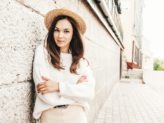 Portrait of beautiful cute model. Female dressed in warm hipster white sweater and hat. Trendy...