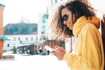 Beautiful  woman with afro curls hairstyle.Smiling model in yellow hoodie. Sexy carefree female...