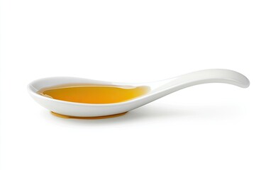 Honey in a small white spoon.  A golden liquid fills a small, shallow, white porcelain spoon with a curved handle.  It sits against a plain white background