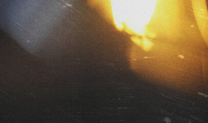 grainy colorful warm orange light leaks on black background with dust texture. abstract damaged...