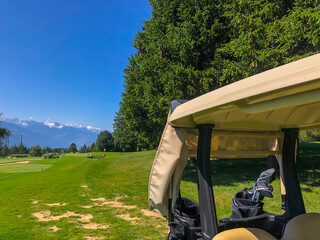 Golf Course with Mountain View and Golf Cart in Crans Montana in Valais, Switzerland.