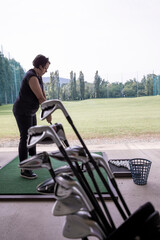 Golfer Practice in Driving Range and a Golf Bag with Golf Clubs in Switzerland.