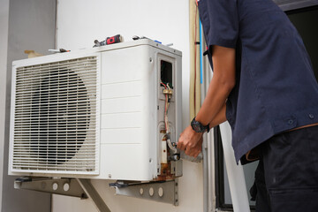Technician Repairing Outdoor Air Conditioning Unit with Wrench, Close-Up of HVAC Maintenance and Repair Work, Professional Air Conditioner Installation or Service in Progress