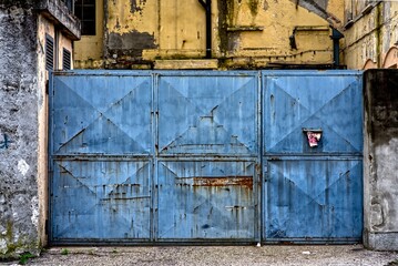 Blue factory gate of an abandoned factory.