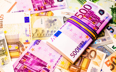 A pack of European currency lies on the background of the Euro

