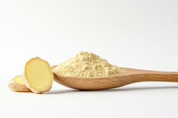Ground ginger powder in wooden spoon, beside fresh ginger slices