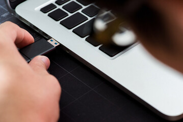 Hand inserting Flash drive memory drive plugged into a computer laptop port.

Hand inserting...