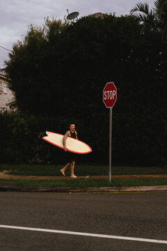 Man walks down the street with a surfboard