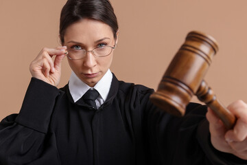 Judge with mallet on light brown background
