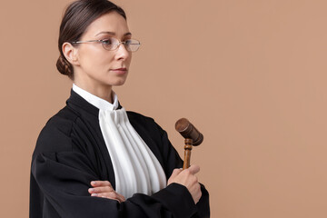 Judge with mallet on light brown background, space for text