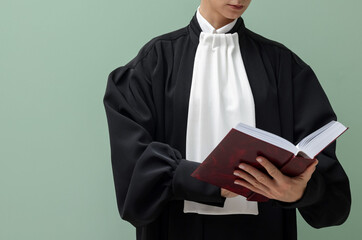 Judge with book on light green background, closeup. Space for text