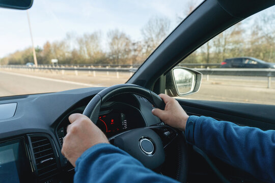 Man driving car with hands on stearing wheel