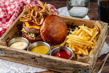 Gourmet beef burger with pastrami, cheddar, caramelized onions, and fries