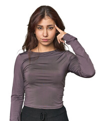 Middle Eastern woman in studio pointing temple with finger, thinking, focused on a task.