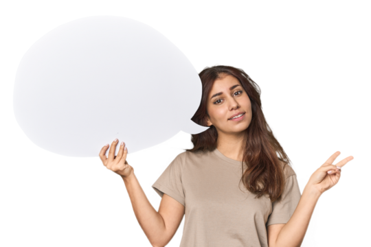 Middle Eastern woman holding comic bubble joyful and carefree showing a peace symbol with fingers.