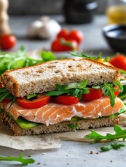 Salmon sandwich with avocado and arugula on whole wheat bread studio shot close up healthy eating