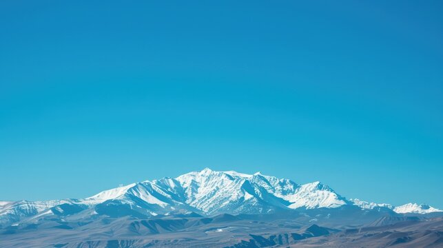 Snow-capped mountains against a clear blue sky as a retirement background.
