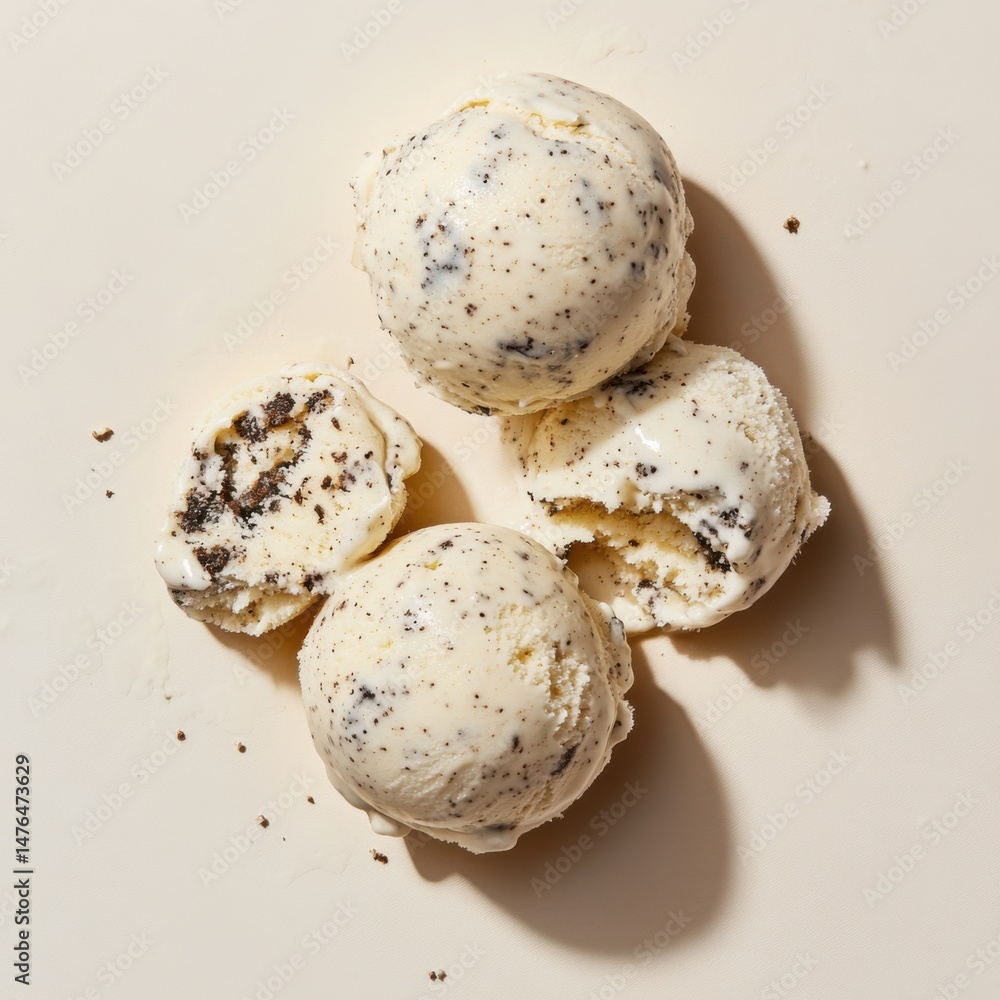 Poster overhead view of four scoops of cookies and cream ice cream on a beige background in studio lighting