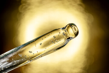An eyedropper with a drop of oil or a cosmetic product for face and body. Natural organic cosmetics. The concept of body care.