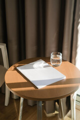 magazine cover mockup design. blank magazine mockup on wooden coffee table with glass of water