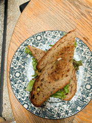 Toasted sandwich with salad filling on patterned ceramic plate,