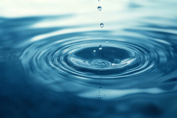 Close up of water droplets falling into a pool creating circular ripples