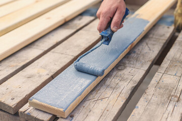 A man paints a board with paint. Selective focus.
