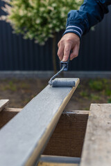 A man paints a board with paint. Selective focus.