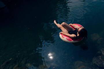 Relaxed Woman in Inner Tube Floating Peacefully on Tranquil River Waters