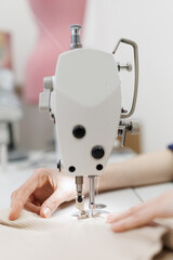 Closeup tailoring process, Designer seamstress women hands behind her sewing clothes.