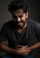 Fototapeta premium Man in Pain: Dramatic Portrait of Abdominal Distress