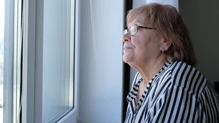 Senior woman resting her chin on her hands while looking outside. Highlights solitude, reflection, and the inspiration to keep moving forward.