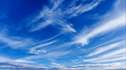 Wide open sky filled with wispy cirrus clouds stretching across a vibrant blue atmosphere. Minimal banner, wallpaper, background, screensaver