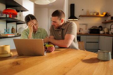 Stressed woman with hand on forehead receiving support from her partner while facing financial...