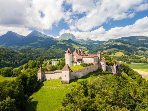 Gruyeres, Switzerland - July 29. 2021: The aerial image of the medieval Gruyeres Castle on the hill top of Alps. It is one of the most popular tourist destionations.
