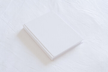 White book mockup on white bed