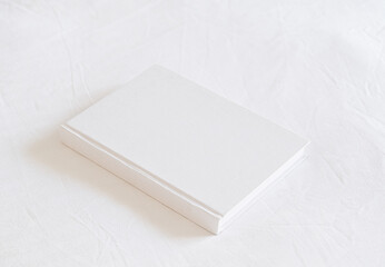 White book mockup on white bed