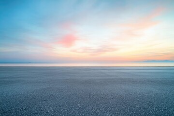 Serene sunrise over calm waters, reflected on empty asphalt