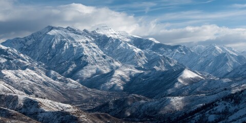 Obraz premium Majestic Snow-Capped Mountains Under Bright Blue Sky With Fluffy Clouds