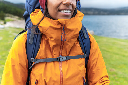 Detail of waterproof technical jacket and backpack on female hiker outdoors