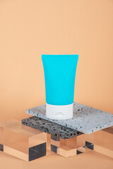 Cosmetic product in tube, bottle, lotion or serum with stylish props on cream background. 