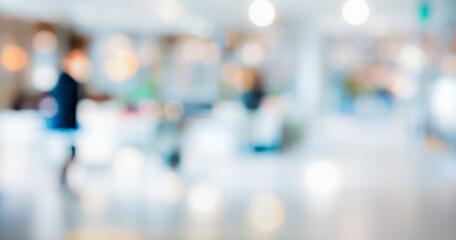 Blurred office interior with people walking, creating a light and airy atmosphere.