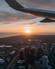 airplane window, sunrise view, sunset view, city from above, aerial view, airplane wing, golden hour, sky from plane, flying above city, city landscape, travel moment, aviation view, sky scenery, airp