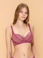Obraz premium Girl model in underwear posing in studio on beige background.
