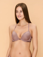 Fototapeta premium Girl model in lingerie posing on beige studio background.