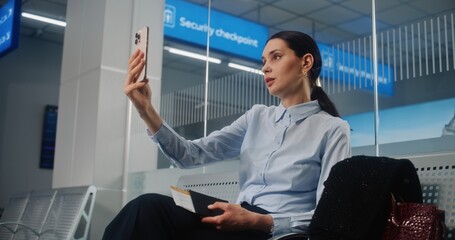 Airport Terminal: Successful Businesswoman Talking to Business Partner on Smartphone by Video Call,...