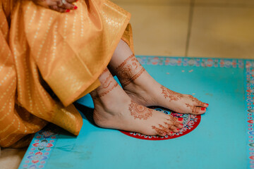 Henna adorned feet on colorful platform. Intricate designs symbolize tradition and celebration,...