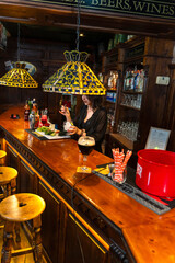 Bartender preparing cocktail in traditional irish pub