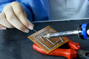 Worker soldering a circuit board