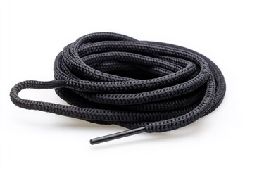 Rolled black shoelaces on white background.  A coiled pair of black laces with a metal tip,  isolated on white
